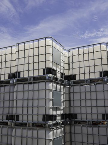 The stock of plastic barrels for the chemical industry. white plastic containers. Chemical industry. The machine brought chemical substances.